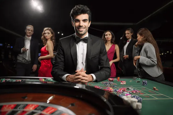TAKSIM BET Casino — Üst düzey casino deneyimine adım atın Neon ışıklarla aydınlatılmış ortamda casino fişleri tutan şık bir kadın, TAKSIM BET’ün premium online casino atmosferini temsil eder.