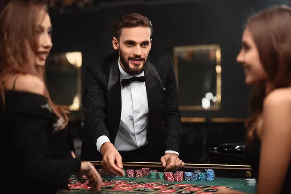 TAKSIM BET Oyunlar — Zengin casino klasiklerini keşfedin Neon casino öğeleriyle çevrili dizüstü bilgisayarında oyun oynayan gülümseyen bir kadın, TAKSIM BET’ün geniş oyun koleksiyonunu sergiler.