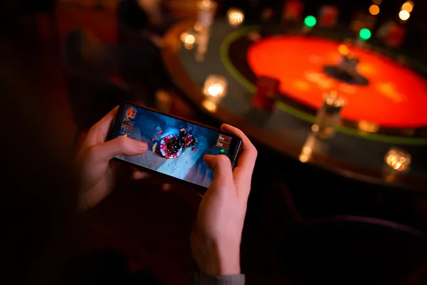Yerel bir etkinlik sırasında akıllı telefon kullanan bir oyuncu, TAKSIM BET’ün mobil uyumlu yapısını gösterir.
