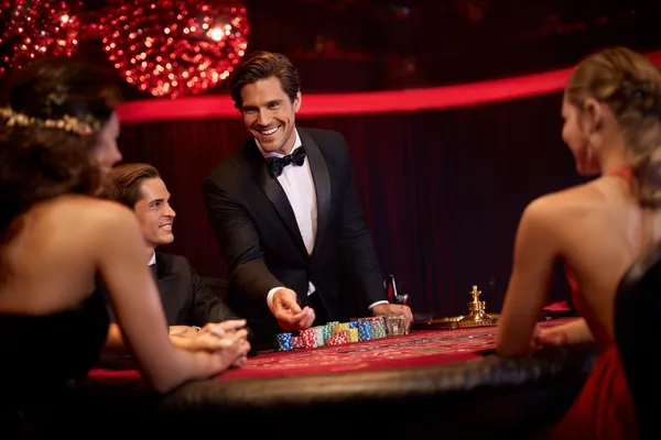 TAKSIM BET Giriş — Hesabınıza anında erişin Casino fişleriyle çevrili kendinden emin bir krupiye, oyuncuları TAKSIM BET hesaplarına giriş yapmaya davet eder.