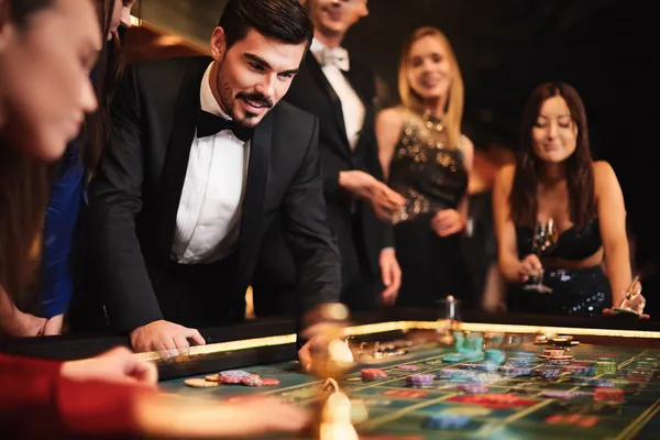 TAKSIM BET Üye Girişi — Kişisel panelinize geri dönün Casino temalı bir arka planda cihaz kullanan bir kişi, TAKSIM BET’e kolay geri dönüş sürecini gösterir.